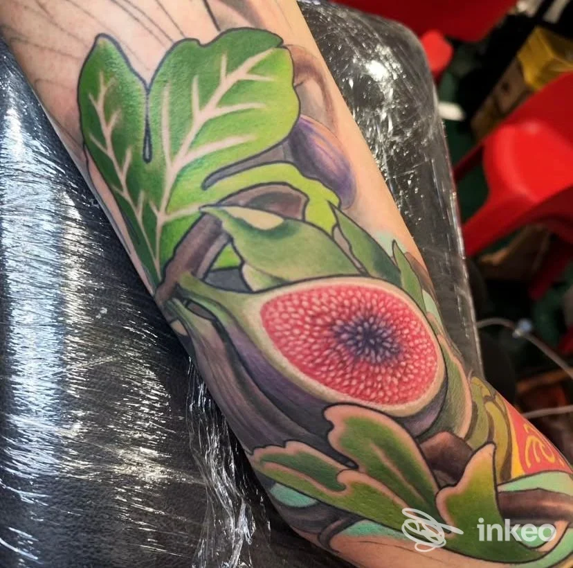Tatuaggio a colori sull'avambraccio con foglie verdi e un frutto aperto dettagliato, LIGHTHAUS TATTOO di Luca Natalini, Montecatini-Terme.