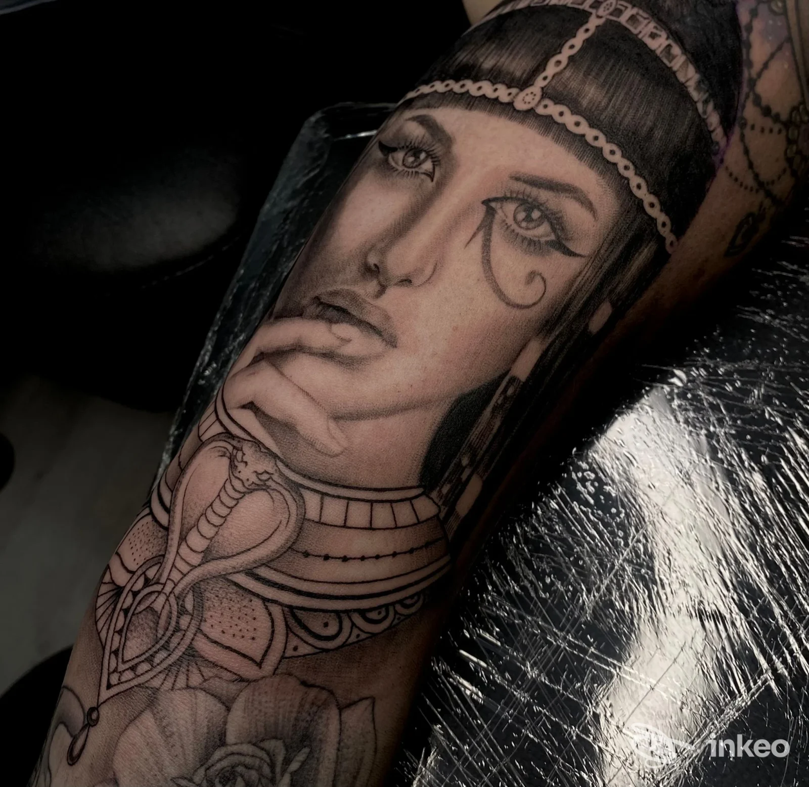 Primo piano di un tatuaggio realistico sul braccio con volto femminile ornamentale, realizzato da Laura Dervishi Tattoo a Massa.