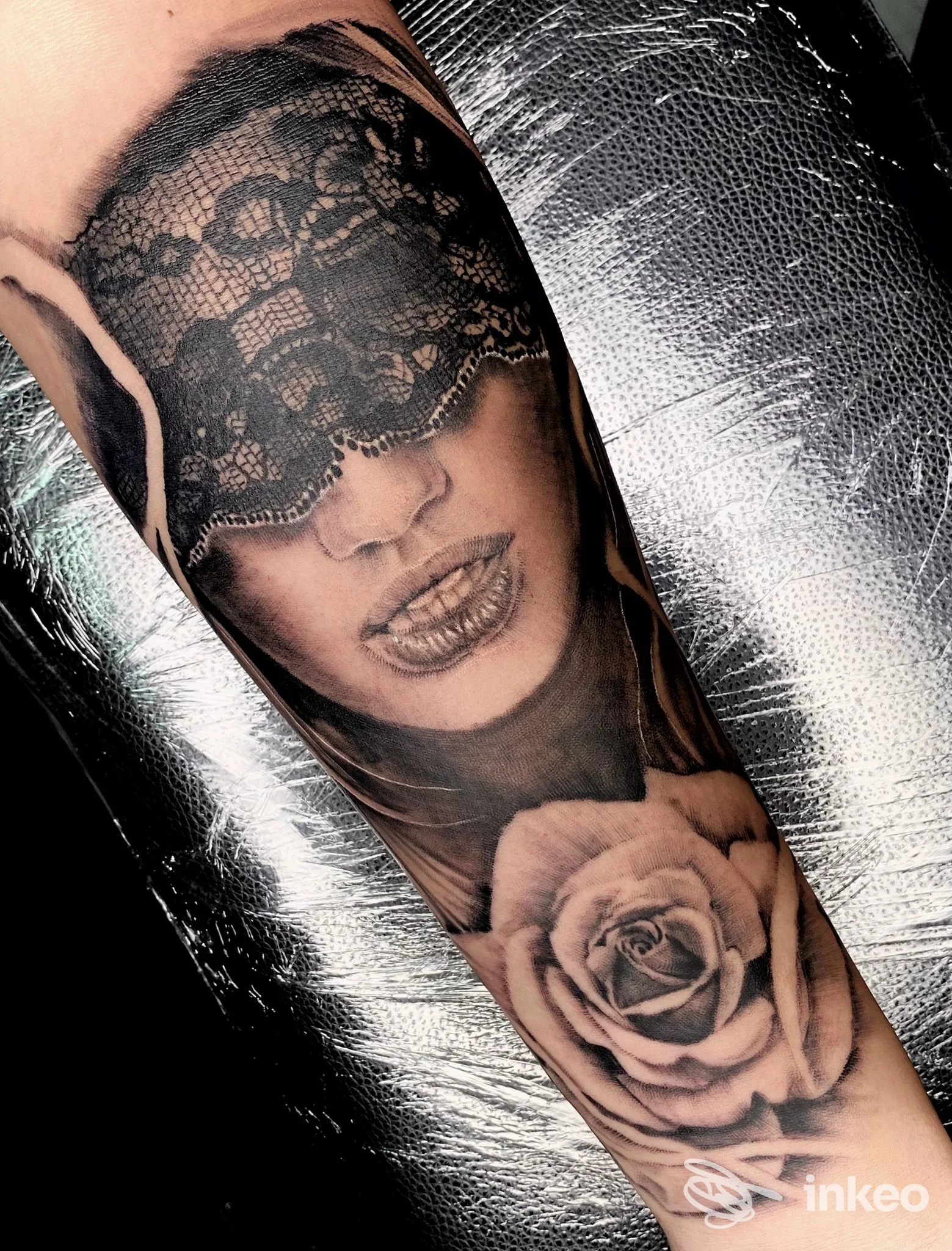 Tatuaggio realistico su avambraccio: volto femminile coperto da pizzo e una rosa. Laura Dervishi Tattoo, Massa.