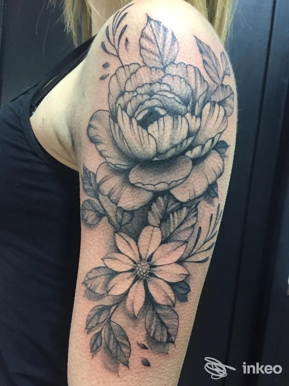 Tatuaggio floreale in nero e grigio sul braccio superiore, foto inviata da Loscafamily Tattoo Piercing, Camucia.
