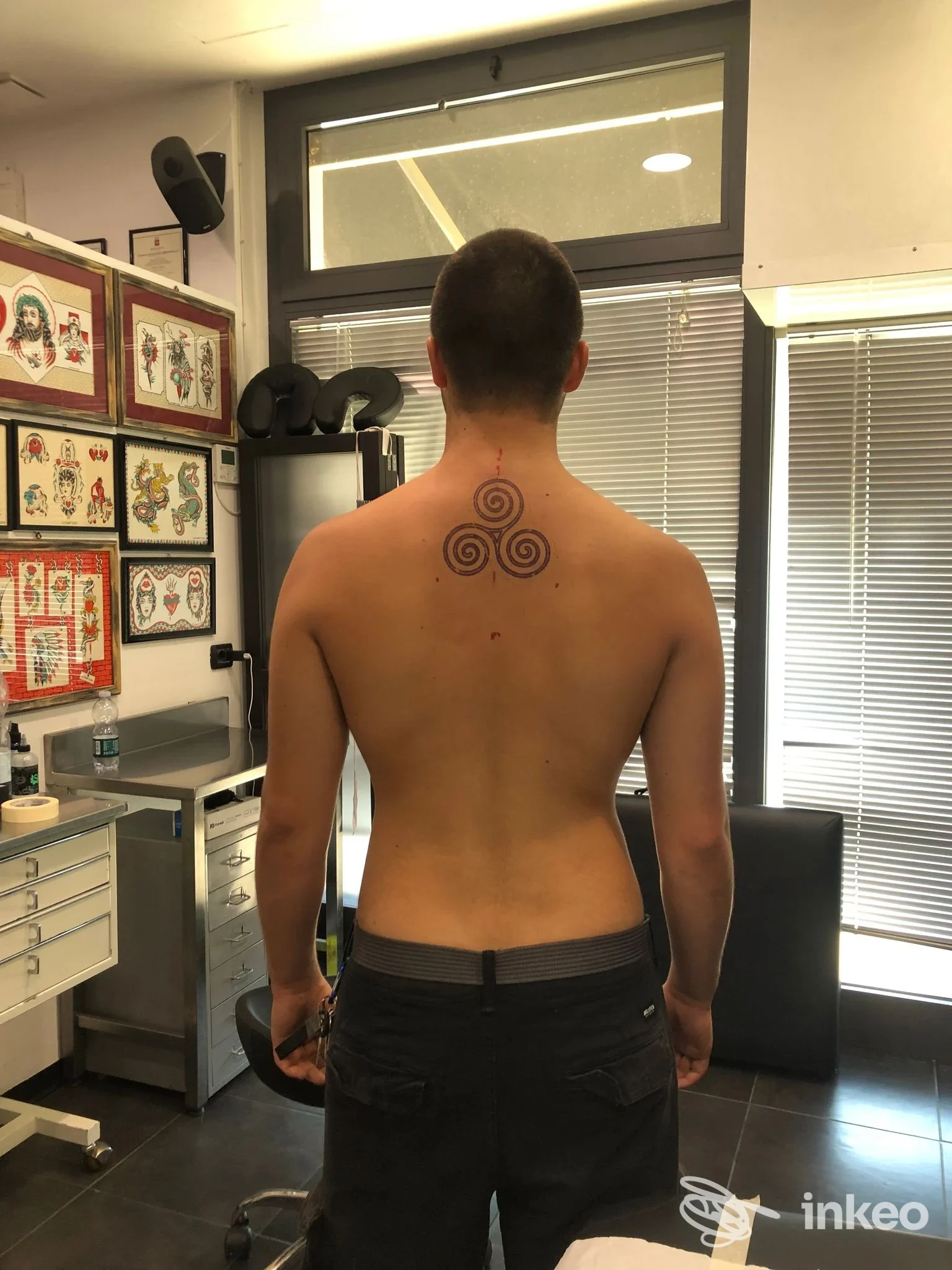 Veduta posteriore nello studio Luci Bart Tattoo - Tatuaggi a Follonica: tatuaggio a tre spirali centrato nella parte alta della schiena.