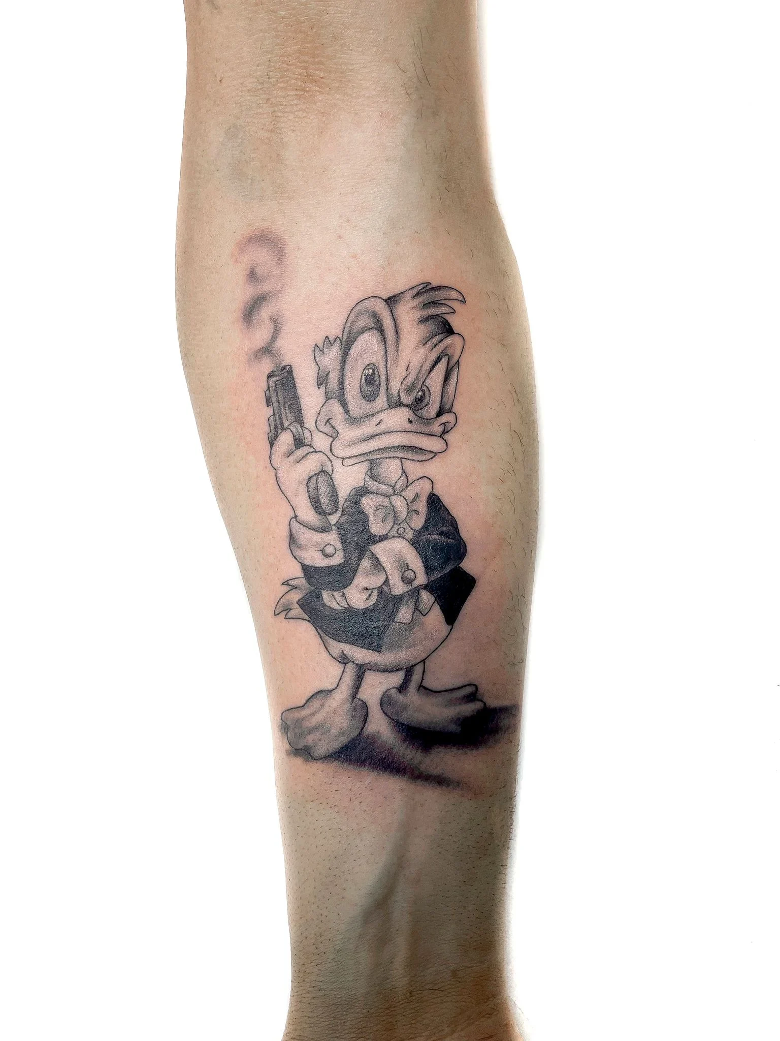 Tatuaggio in bianco e nero su avambraccio realizzato da Mako Tattoo, Montignoso, rappresentante un personaggio cartoonesco.