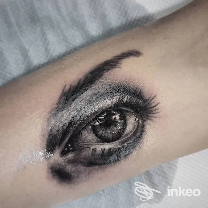 Tatuaggio realistico di un occhio in bianco e nero sull'avambraccio, realizzato da Mano Viva Tattoo Club, Firenze.