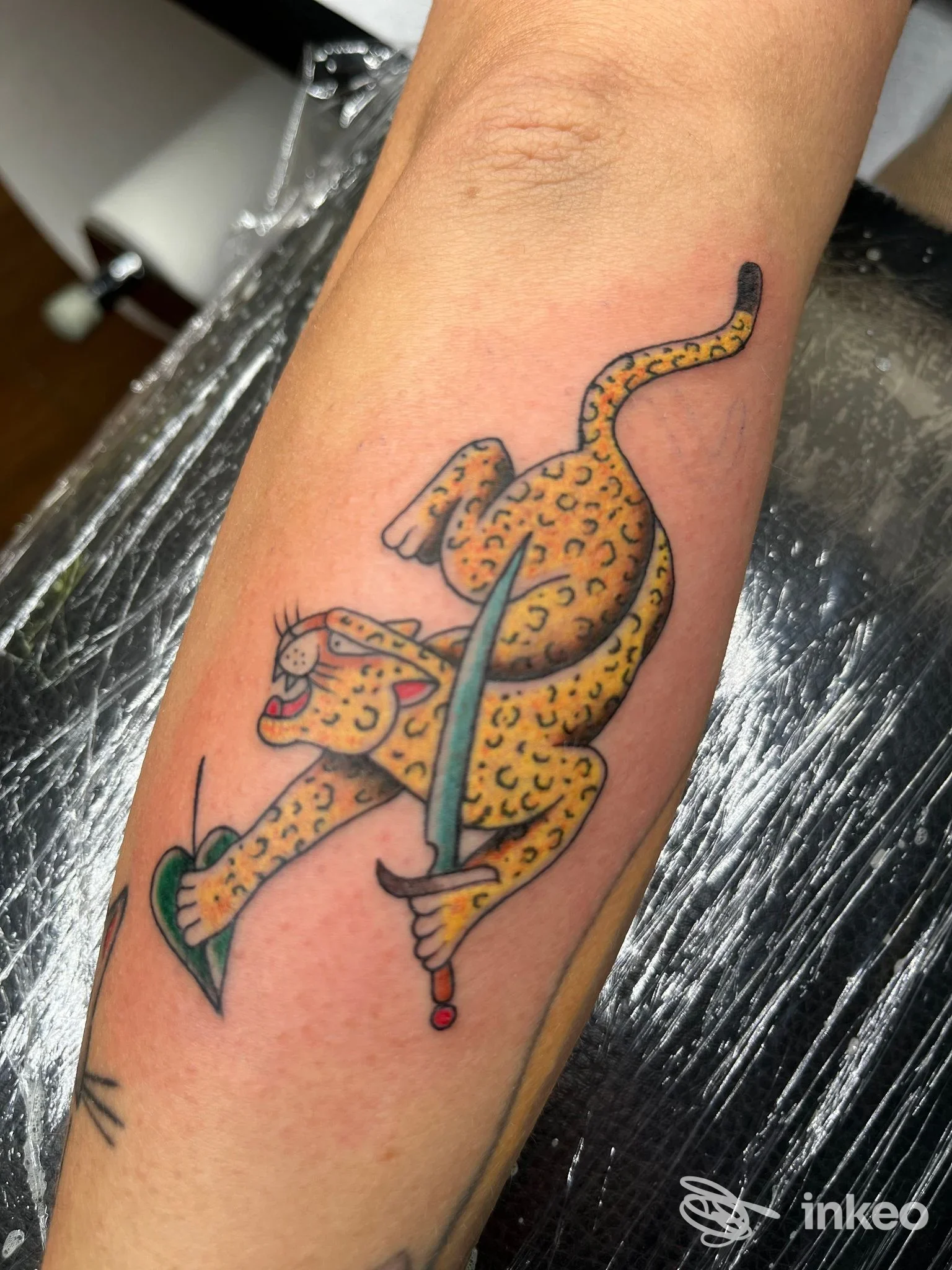 Tatuaggio di un leopardo stilizzato che impugna una spada sull'avambraccio, NEDO TATTOO, Camaiore.