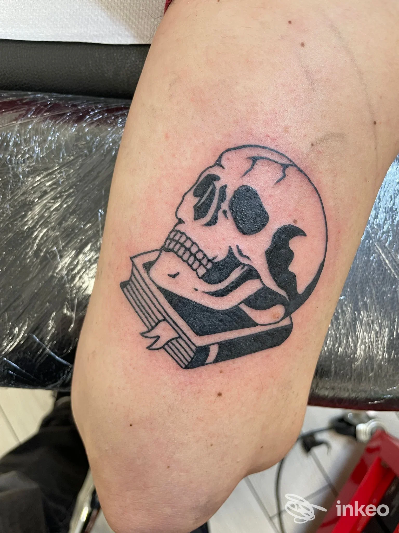 Tatuaggio di un teschio su libro in nero sull'avambraccio, foto da Obsolete Tattoo studio ad Arezzo.
