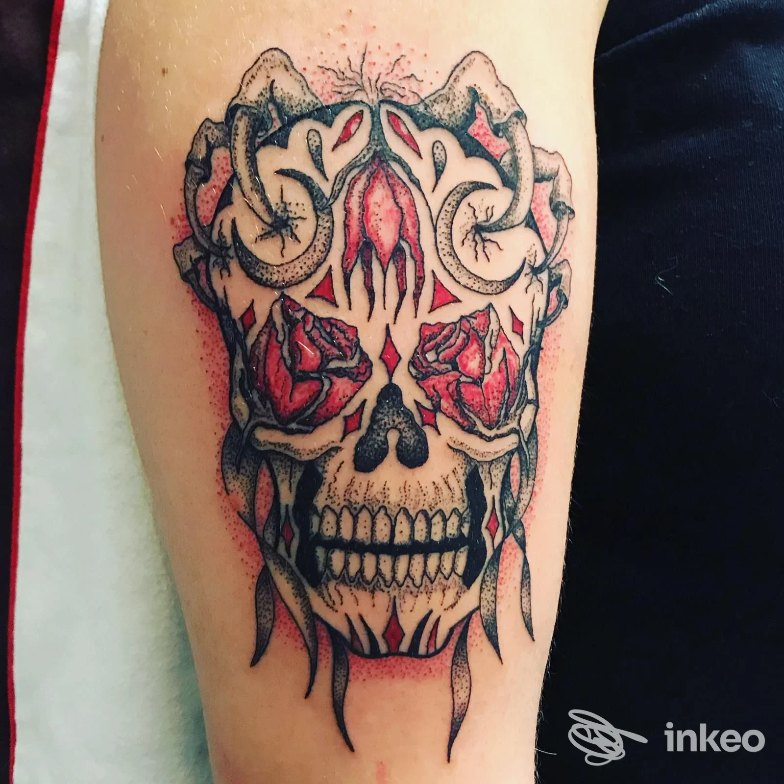 Tatuaggio su braccio con teschio ornamentale e rose, realizzato da Officina Tatuaggi a Ponsacco.