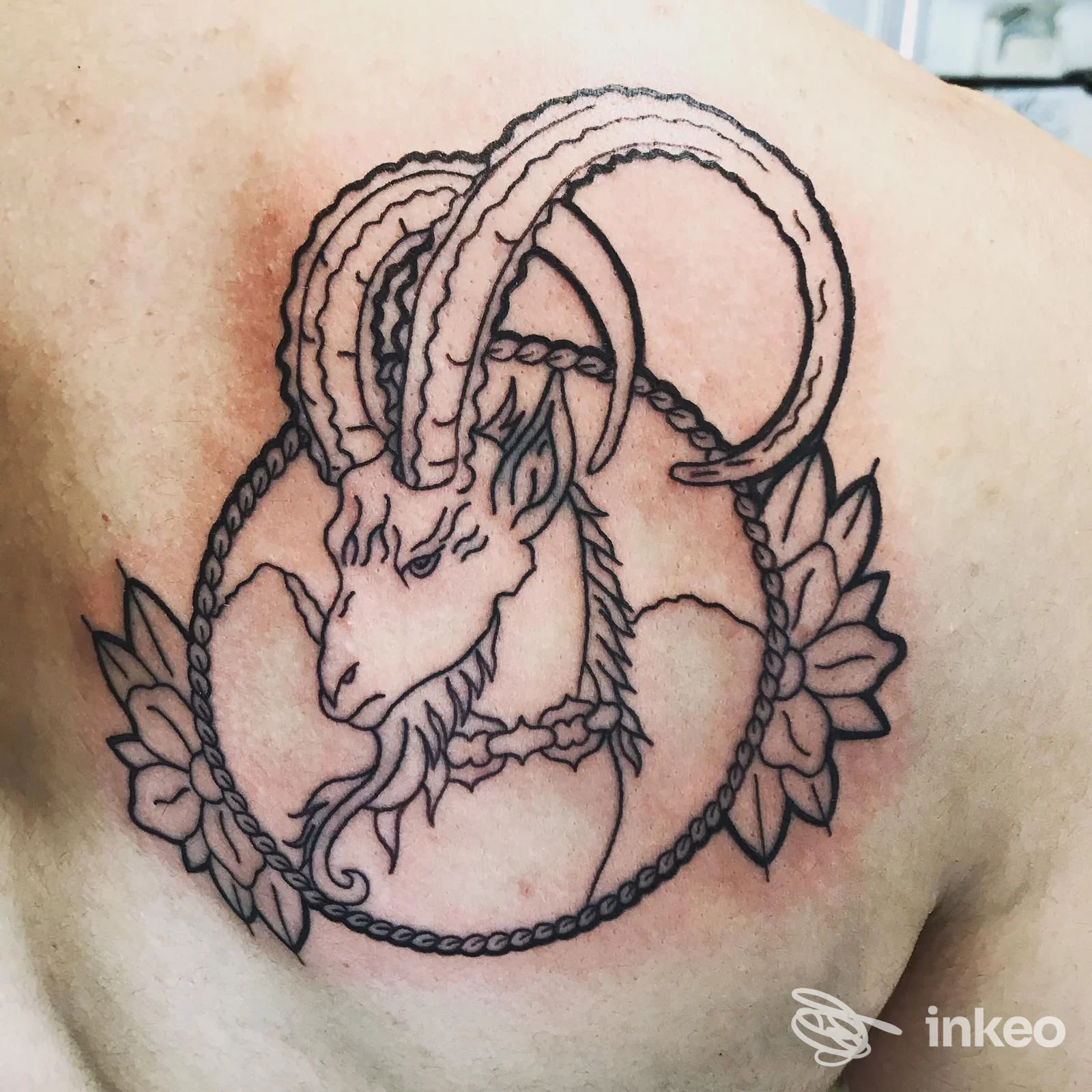 Tatuaggio a linee nere raffigurante la testa di un caprone sulla spalla, eseguito da Officina Tatuaggi a Ponsacco.