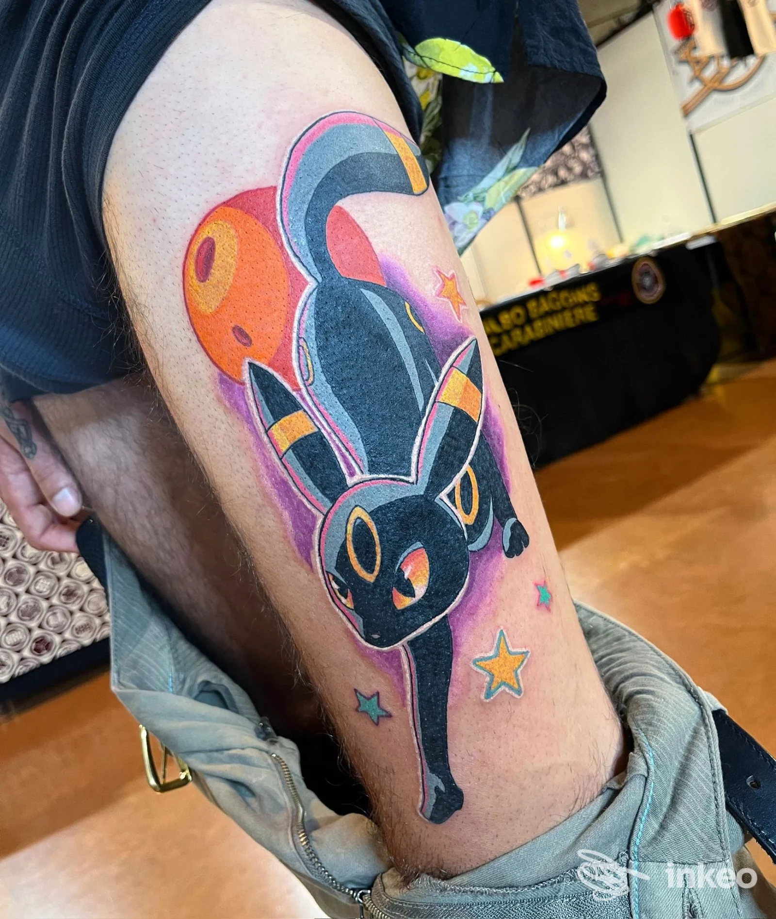 Tatuaggio colorato di Umbreon stilizzato sulla coscia sinistra, fotografato allo studio Old Boys Electric Tattoo a Livorno.