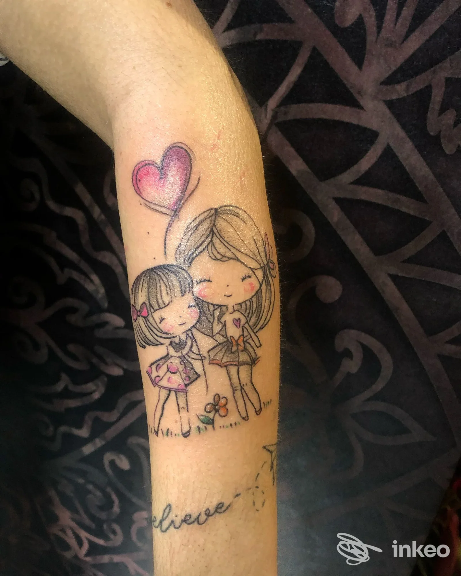Tatuaggio sull'avambraccio con due bambine stilizzate e un palloncino a forma di cuore - Red Dot Tattoo studio di Cecilia Cuomo, Foiano della Chiana.