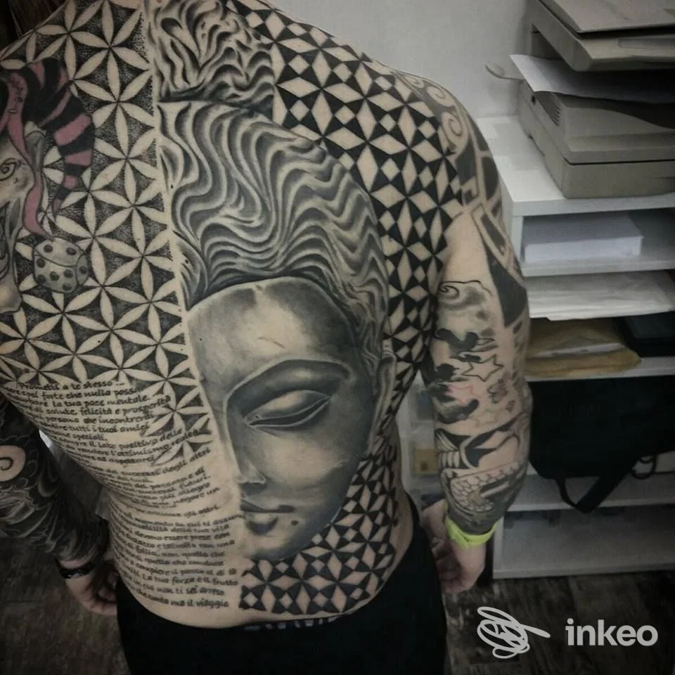 Ampia schiena tatuata con volto stilizzato e pattern geometrici, foto dallo studio Red House Tattoo Livorno, Livorno.