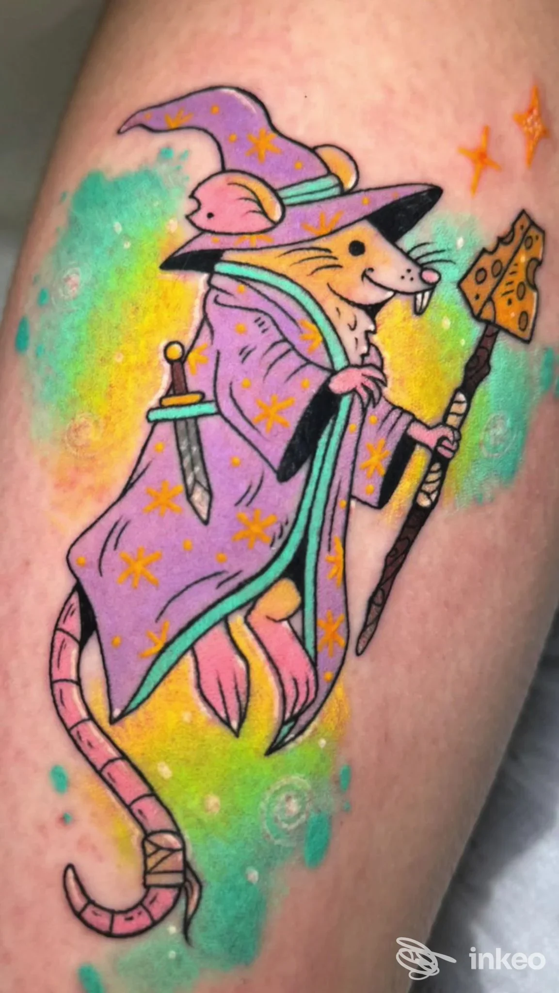 Tatuaggio colorato stile cartoon di un topo mago con cappello e bastone su pelle, realizzato da Rott3n Tattoo a Livorno.