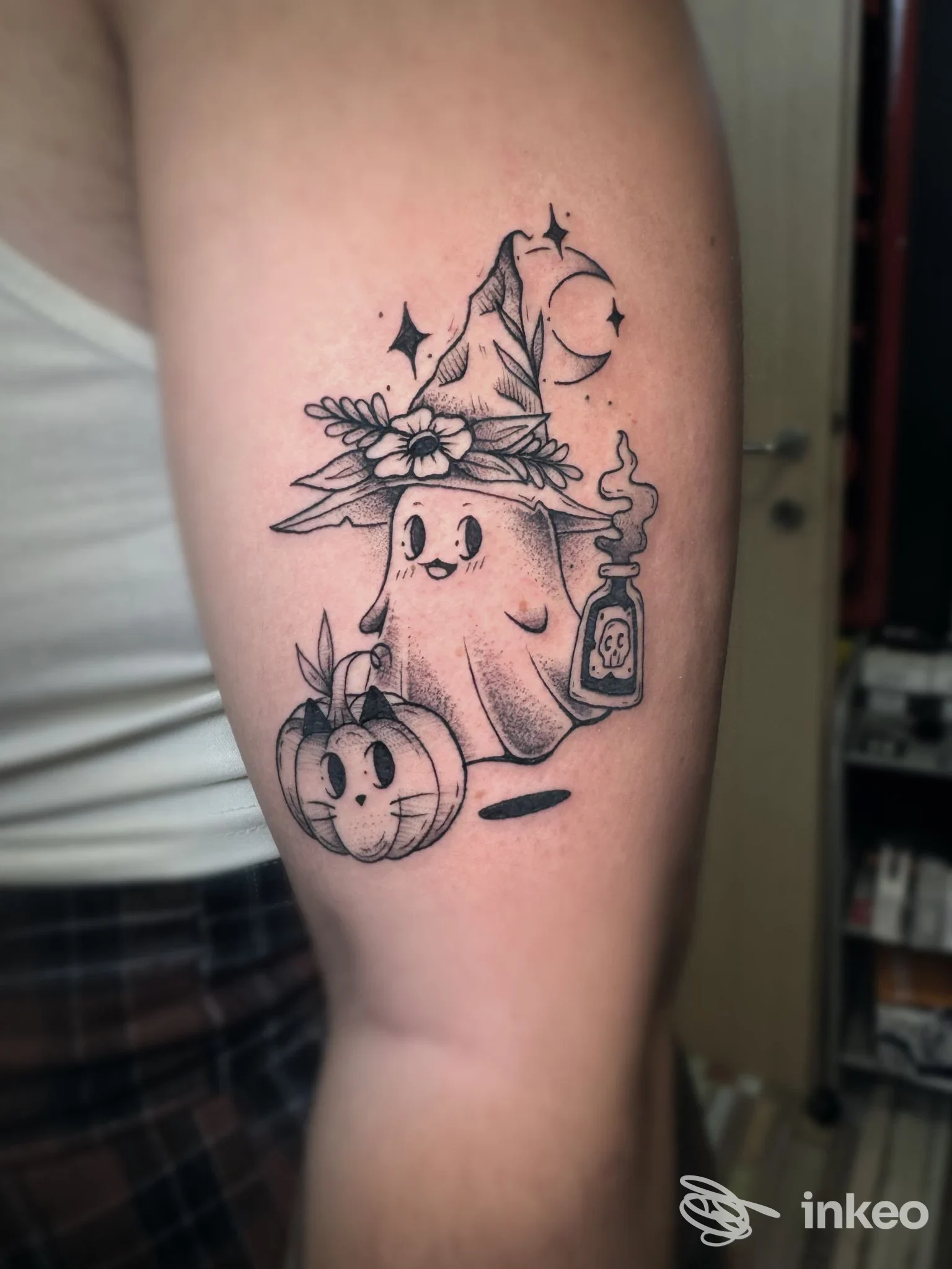 Tatuaggio su avambraccio con fantasmino in stile cartoon, zucca e boccetta fumante, realizzato da Rott3n Tattoo a Livorno.