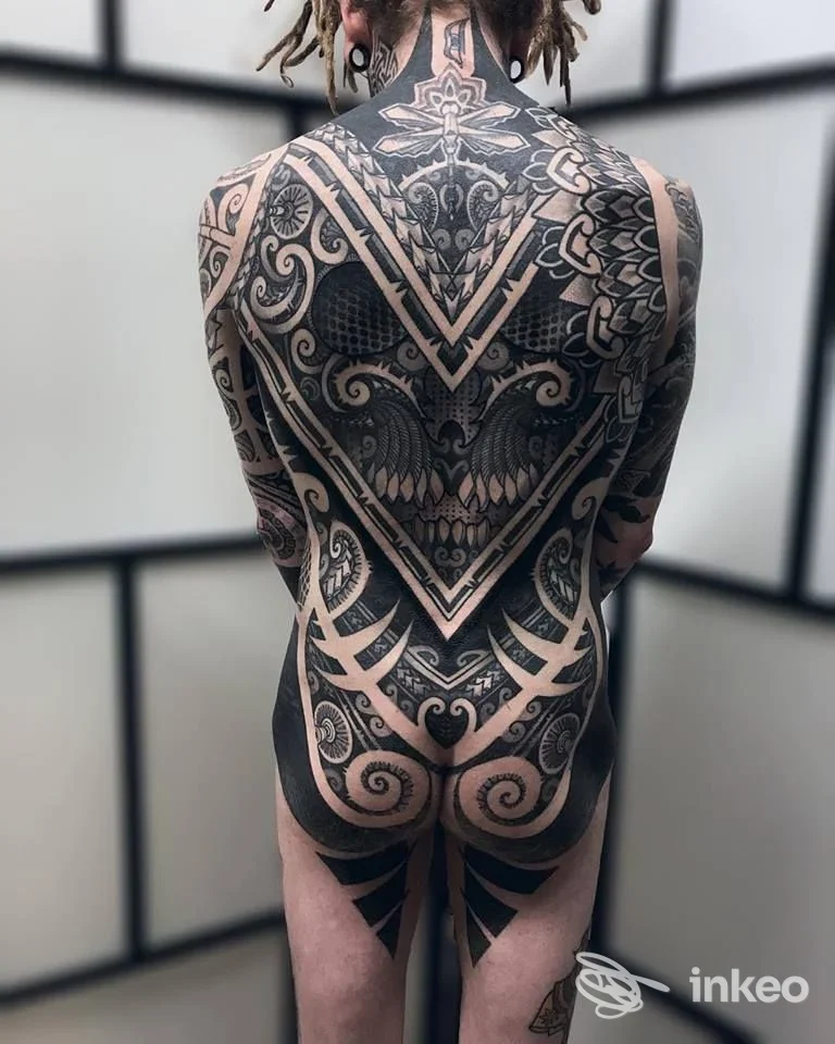 Vista posteriore di un tatuaggio blackwork ornamentale che copre la schiena e la parte superiore delle gambe, foto dallo studio SCRIBATATTOO a Calcinaia.
