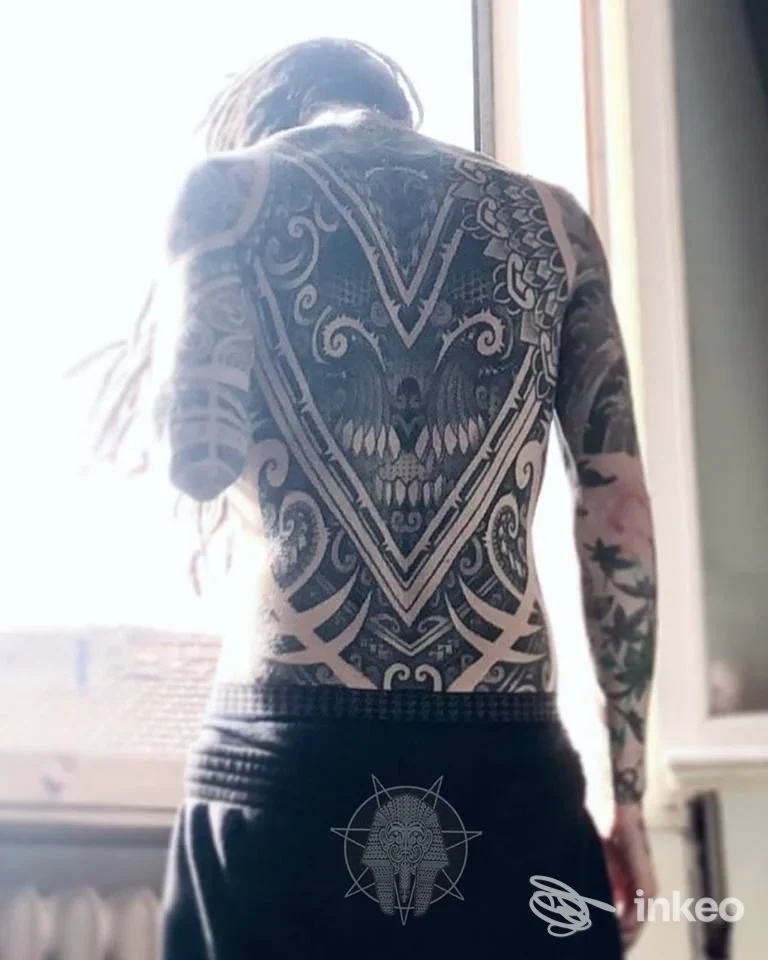 Schiena completamente tatuata con grande motivo ornamentale e maschera centrale, foto inviata da SCRIBATATTOO a Calcinaia.