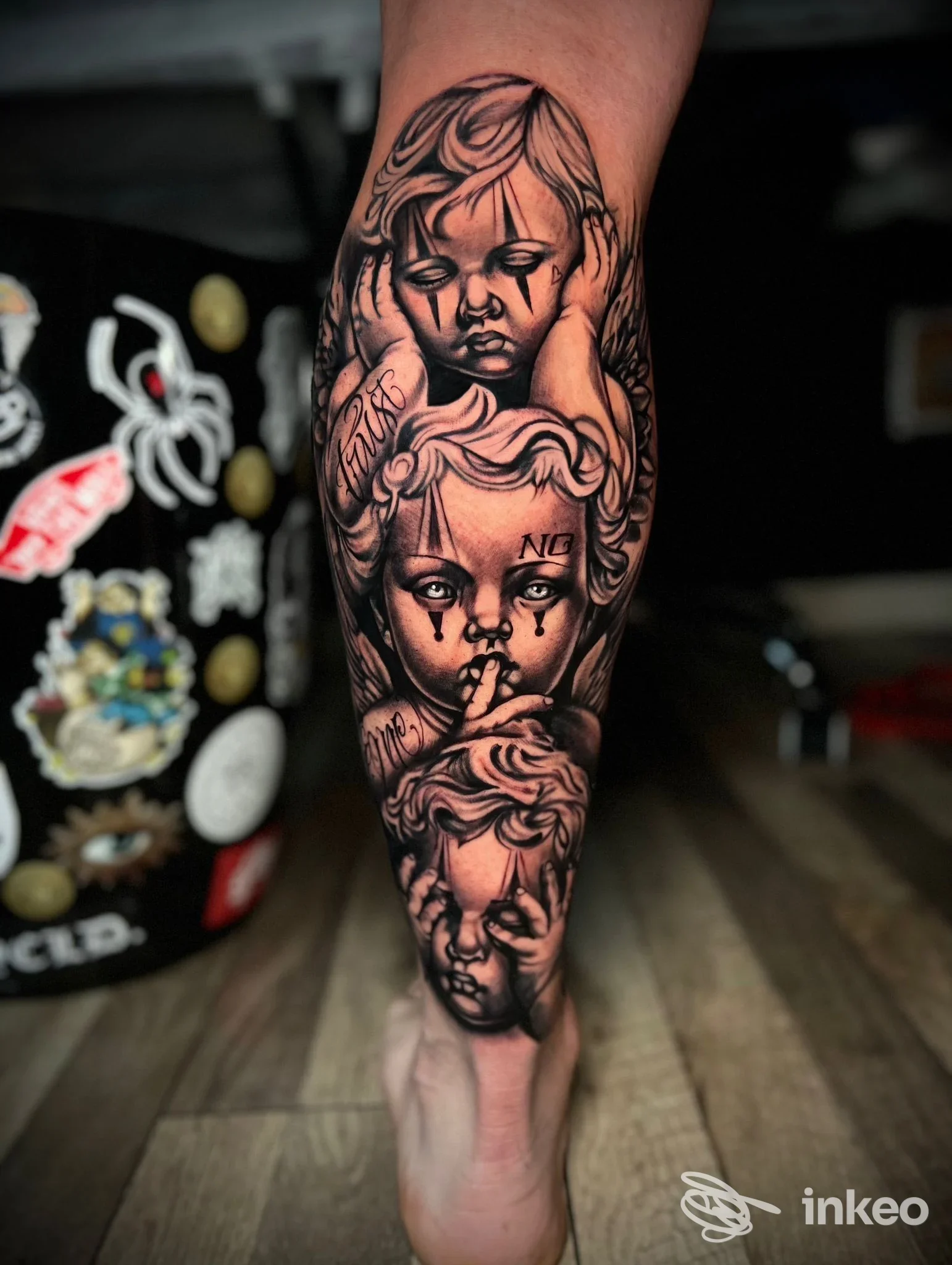 Tatuaggio in bianco e nero su avambraccio con tre teste di putto impilate, opera visibile nello studio Sorry Mom Tattoo a Livorno.