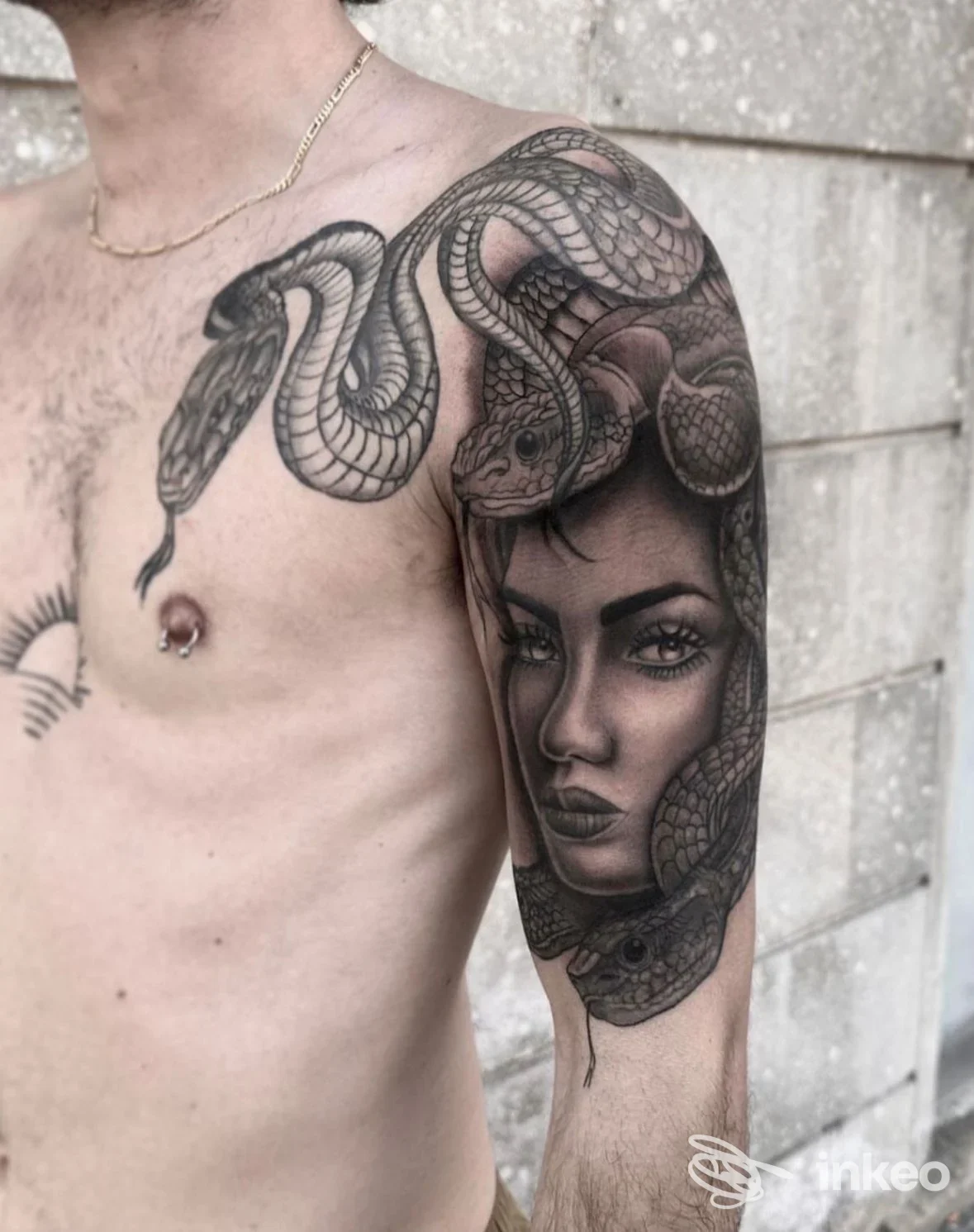 Tatuaggio realistico in bianco e nero su spalla e braccio con volto femminile e serpenti, realizzato da Sorry Mom Tattoo a Livorno.