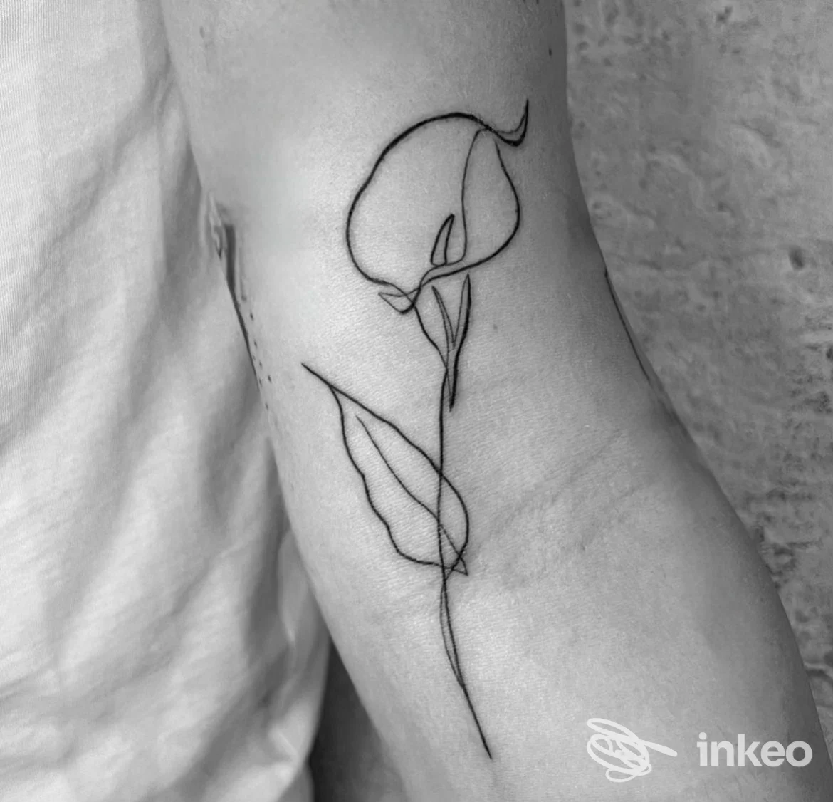 Tatuaggio minimal a linee sottili di una calla sull'avambraccio interno, studio Tattoo studio Tosi Lorenzo a Livorno.