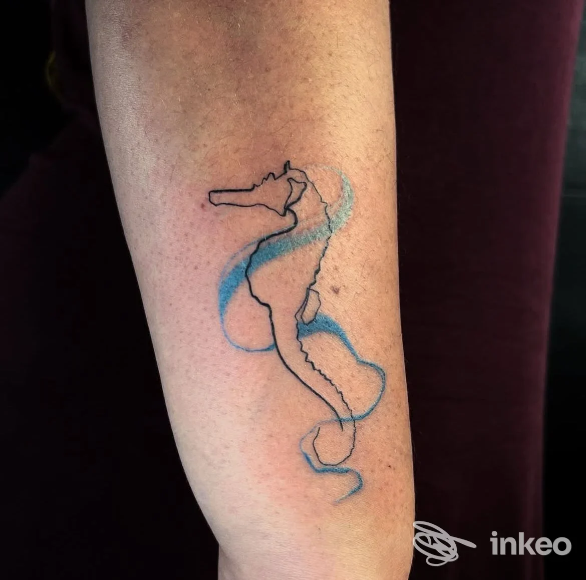 Tatuaggio di cavalluccio marino con linee nere e acquerello blu sull'avambraccio, Tattoo studio Tosi Lorenzo, Livorno.