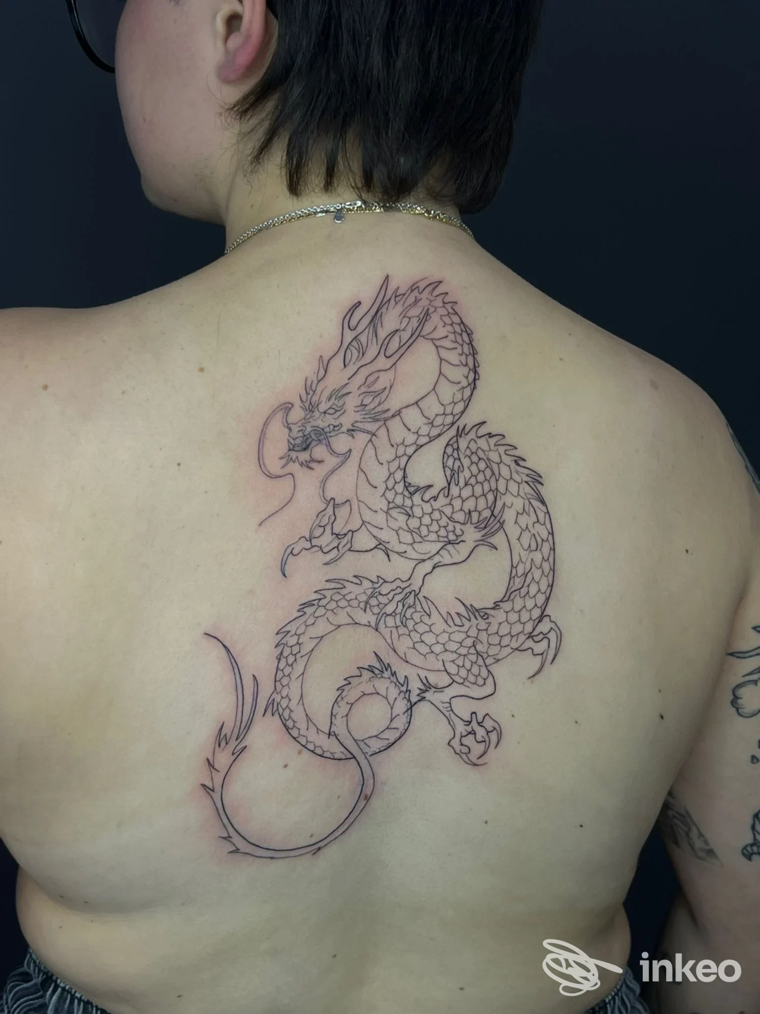 Tatuaggio a contorno di drago sulla parte alta della schiena, foto fornita dallo studio Tattoo studio Tosi Lorenzo, Livorno.