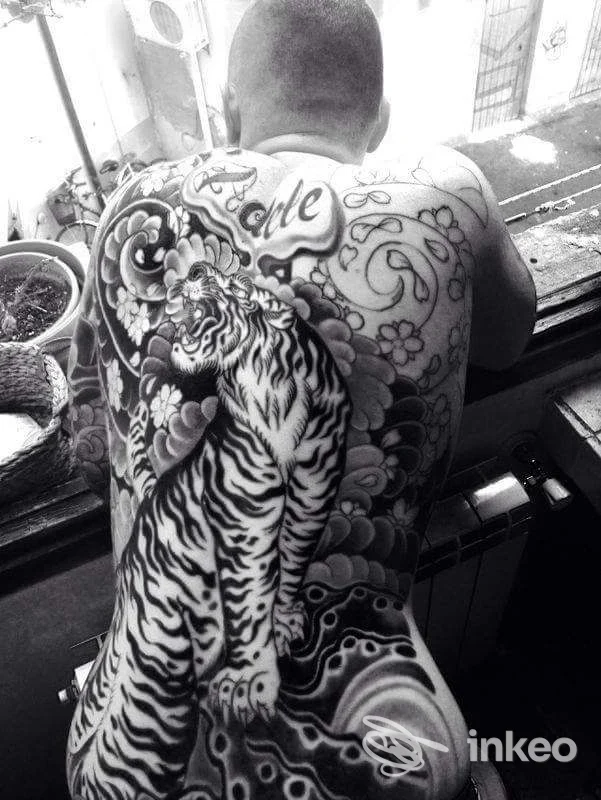 Grande tatuaggio a schiena intera con tigre e sfondi orientali, fotografia dal vivo. Tatuaggi Di Marco Fantoni, Livorno.