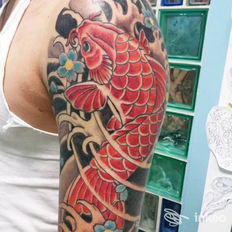 Tatuaggio di carpa rossa su spalla e braccio, realizzato da Tatuando Di Squarcia Mara a Grosseto.