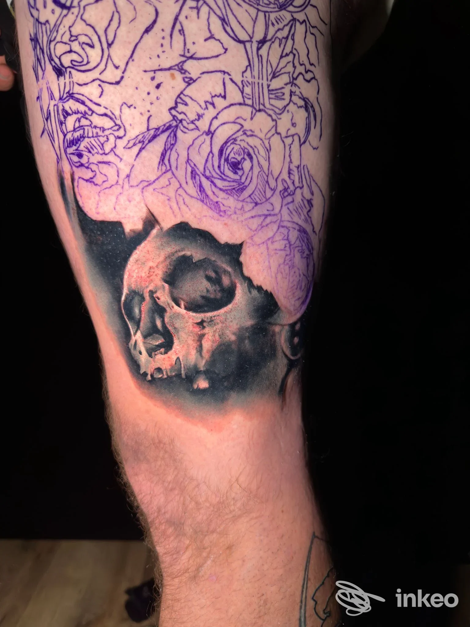 Tatuaggio in corso su coscia con teschio in bianco e nero e stencil di rose viola, The OutLine Art Studio, Carrara.