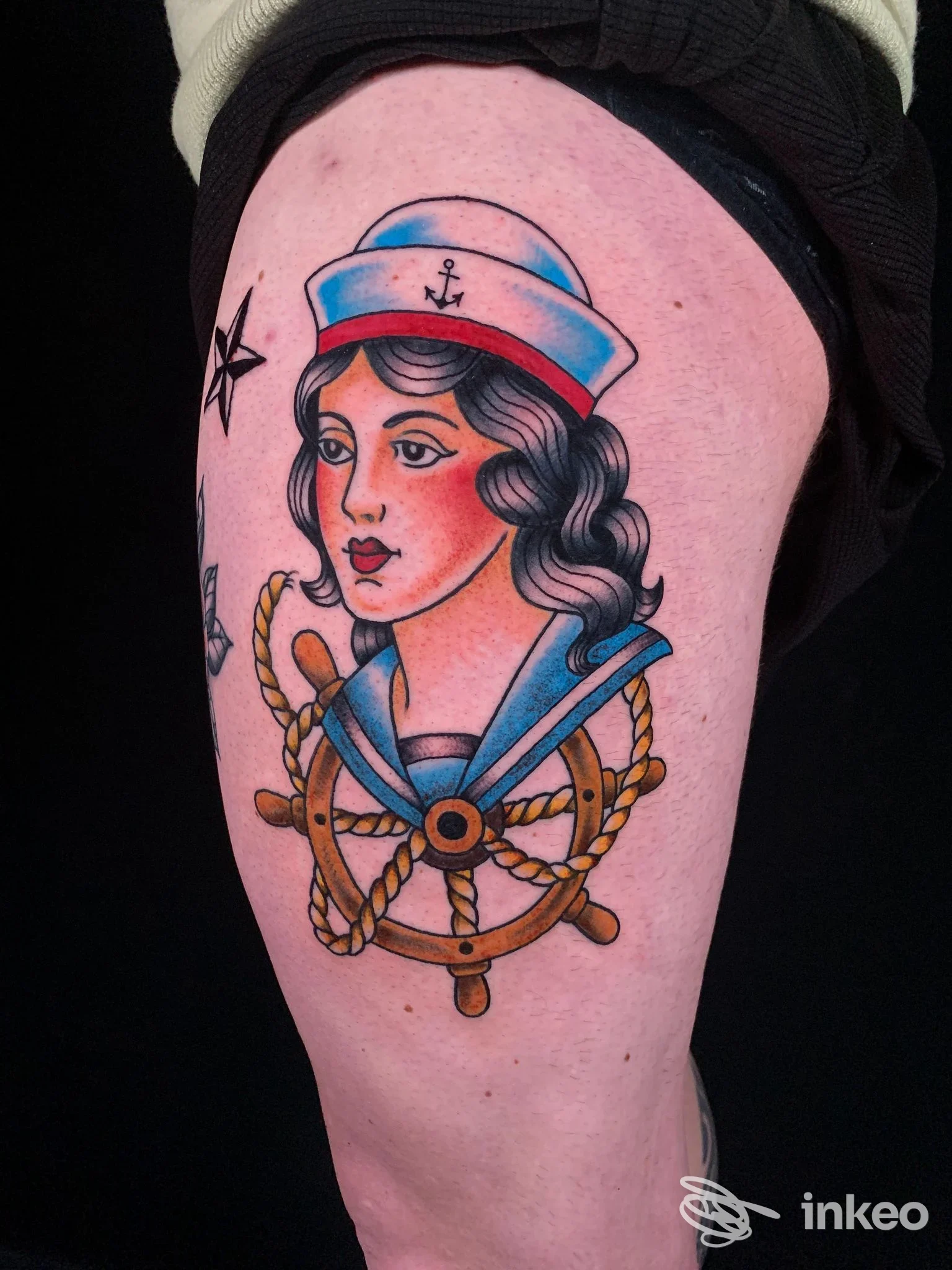 Tatuaggio tradizionale su coscia: marinaia con timone e cordame, colori pieni e contorni netti. TheSacredInk by leletattoo, Viareggio.