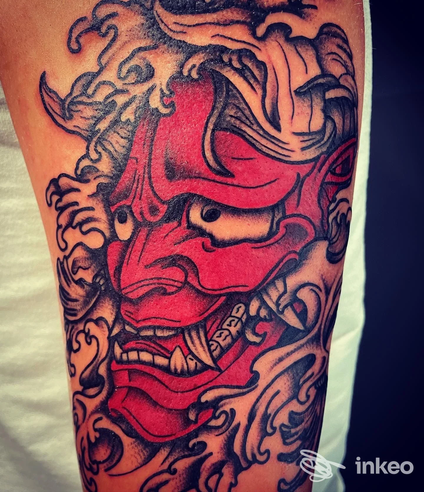 Tatuaggio a colori a forma di maschera demoniaca rossa e nera sull'avambraccio, foto inviata dallo studio 50 Sfumature di Tattoo ad Arezzo.