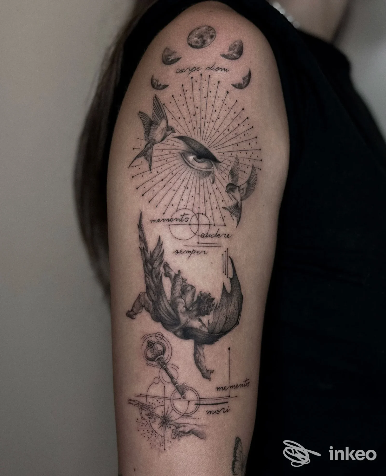 Grande tatuaggio in bianco e nero sull'alto braccio con occhio, fasi lunari e elementi geometrici — ATTITUDE Tattoo Studio, Massa.