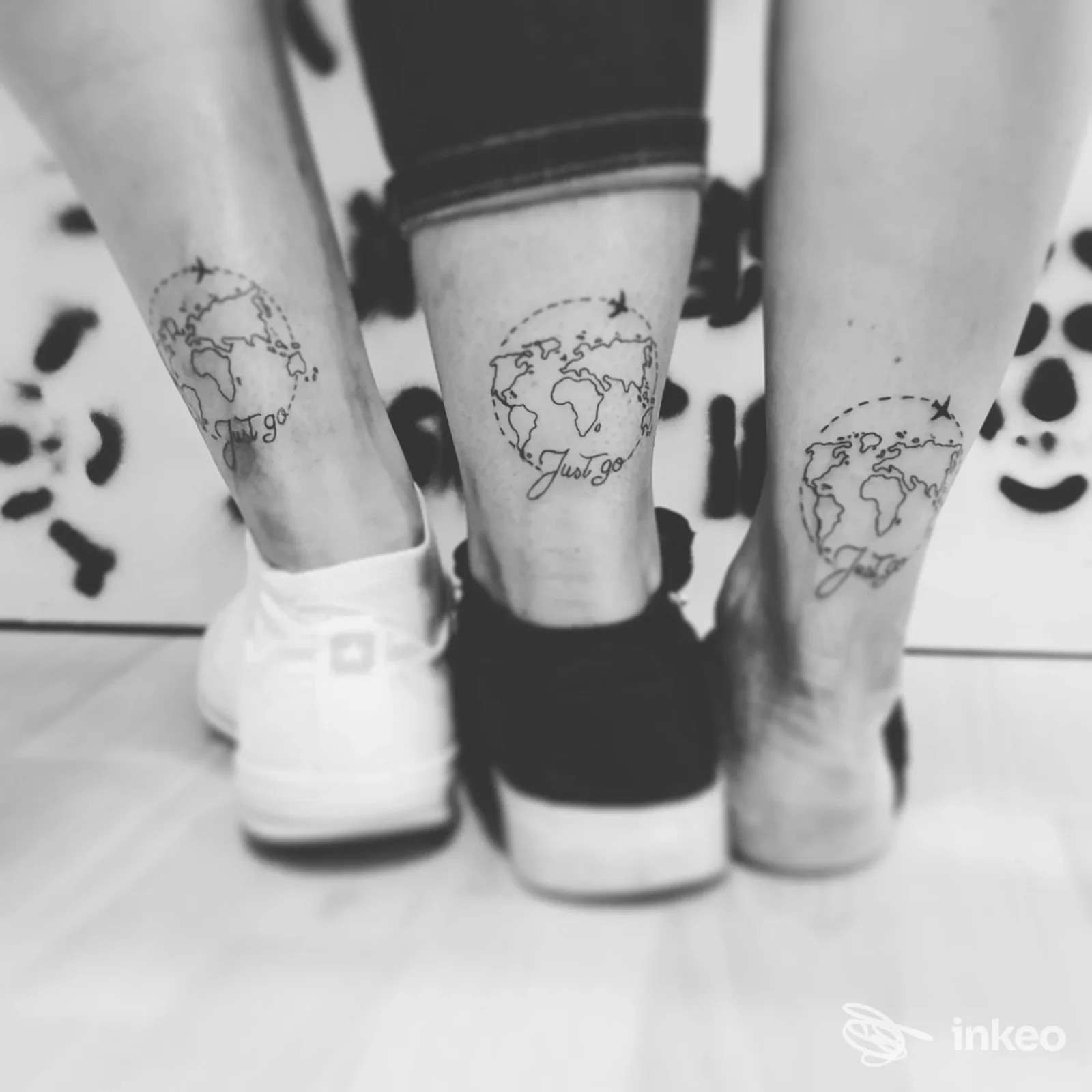 Tre tatuaggi identici del globo con aeroplano e la scritta "Just go" sulle caviglie, scattati per Valkyrja Tattoo Studio di Sonia Staccioli, Siena.