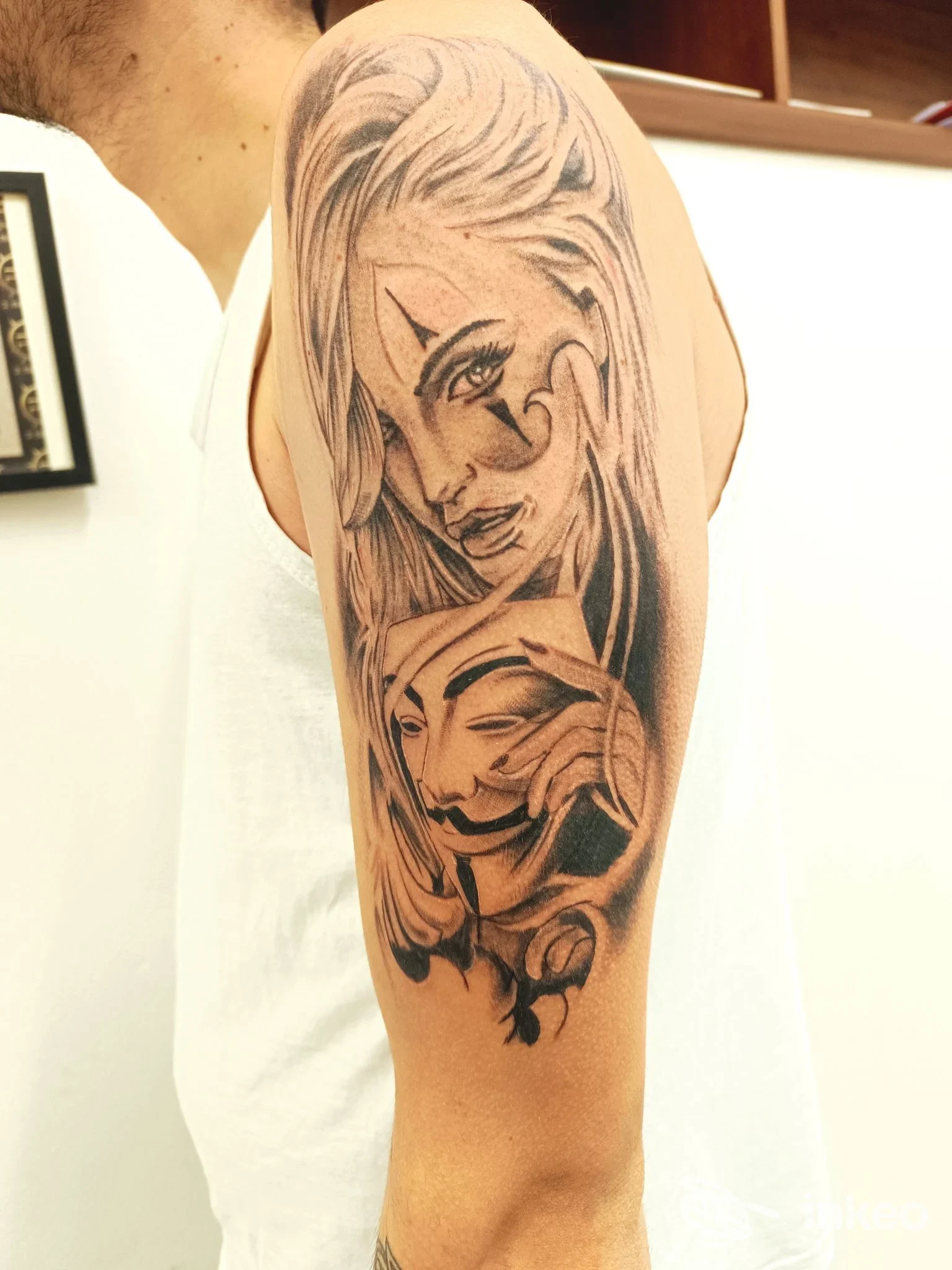 Grande tatuaggio in bianco e nero sul braccio superiore, volto stilizzato nell'opera. VinzTattoo, Foiano della Chiana.
