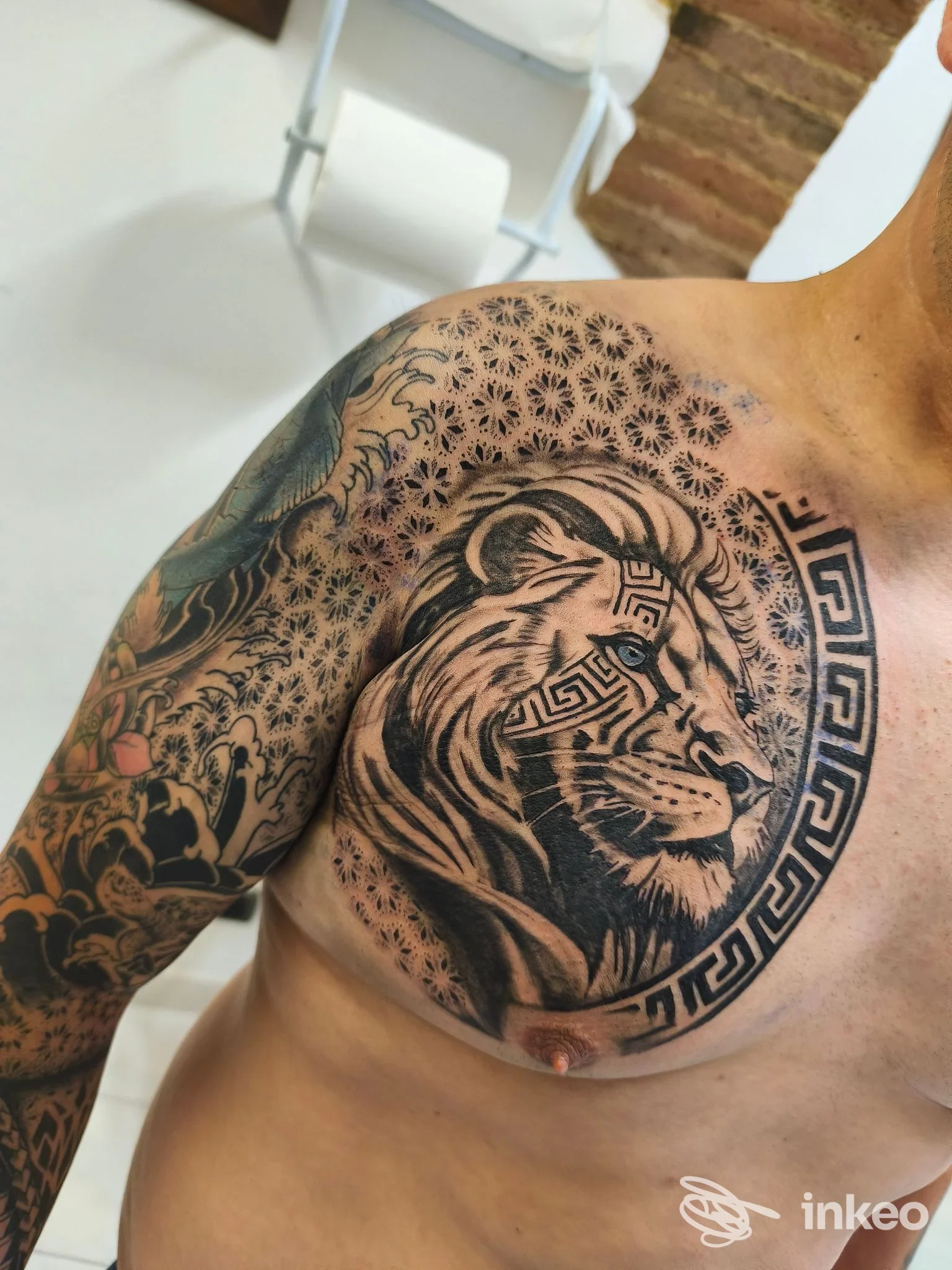 Grande tatuaggio su petto e spalla con testa di leone e motivi geometrici, realizzato da VinzTattoo a Foiano della Chiana.