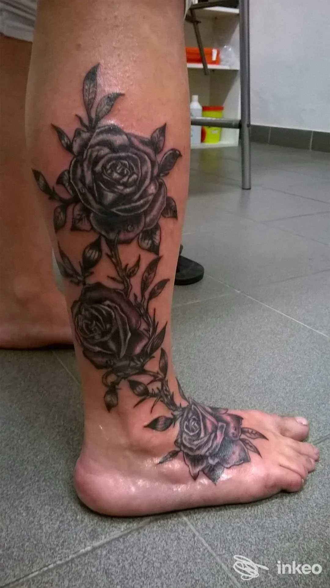 Tatuaggio a tema rose in nero/grigio su polpaccio e dorso del piede, foto fornita da Ale Tattoo Piercing a Livorno.