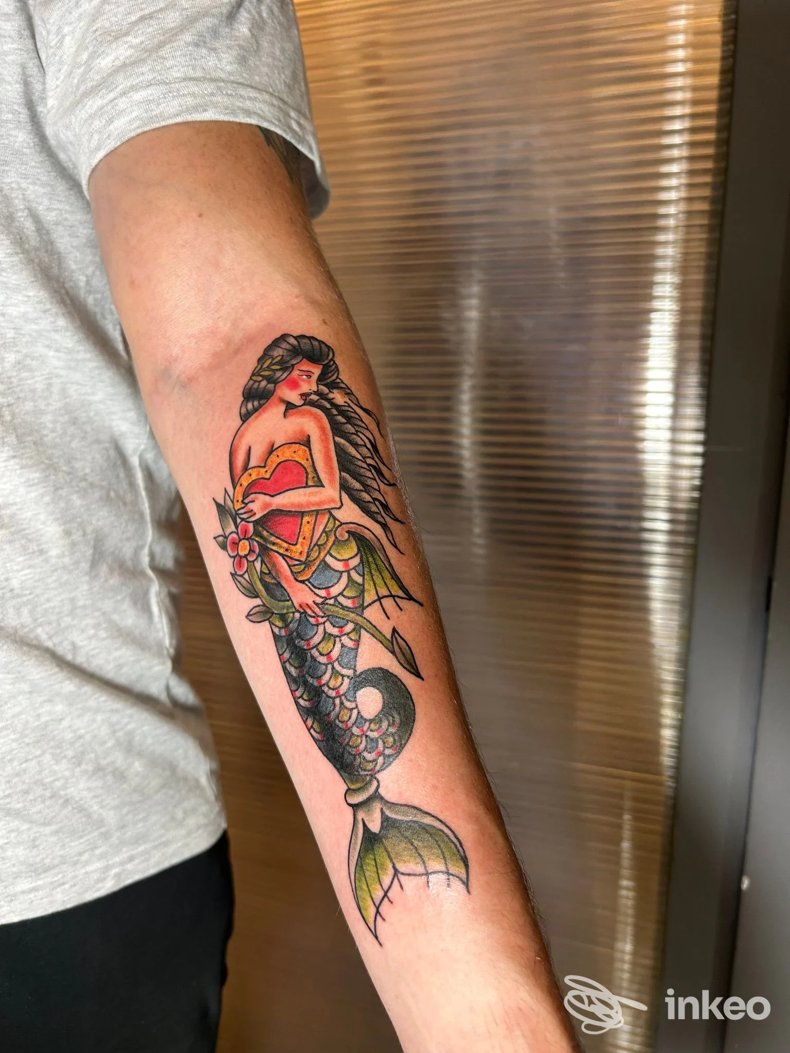 Tatuaggio colorato di una sirena sull'avambraccio, eseguito da Amuleto Ritual Tattoo a Firenze, fotografia in interno.