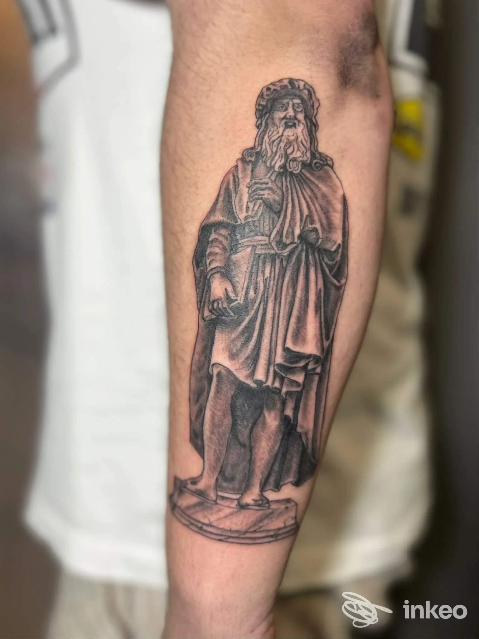 Tatuaggio realistico in bianco e nero di una figura/statua sull'avambraccio, eseguito da Amuleto Ritual Tattoo a Firenze.