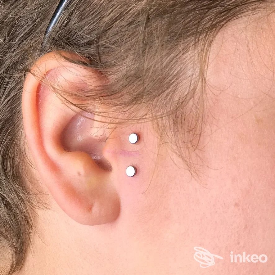 Primo piano di orecchio con due microdermal posizionati vicino al padiglione, foto di Anele Piercing a Firenze.