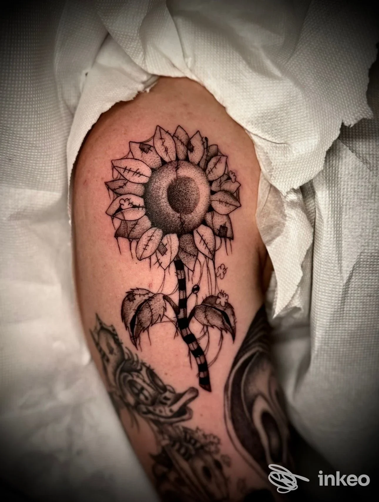 Tatuaggio blackwork/dotwork di un girasole sul braccio superiore, realizzato da blackladyinktattoo_studio a Cintolese.