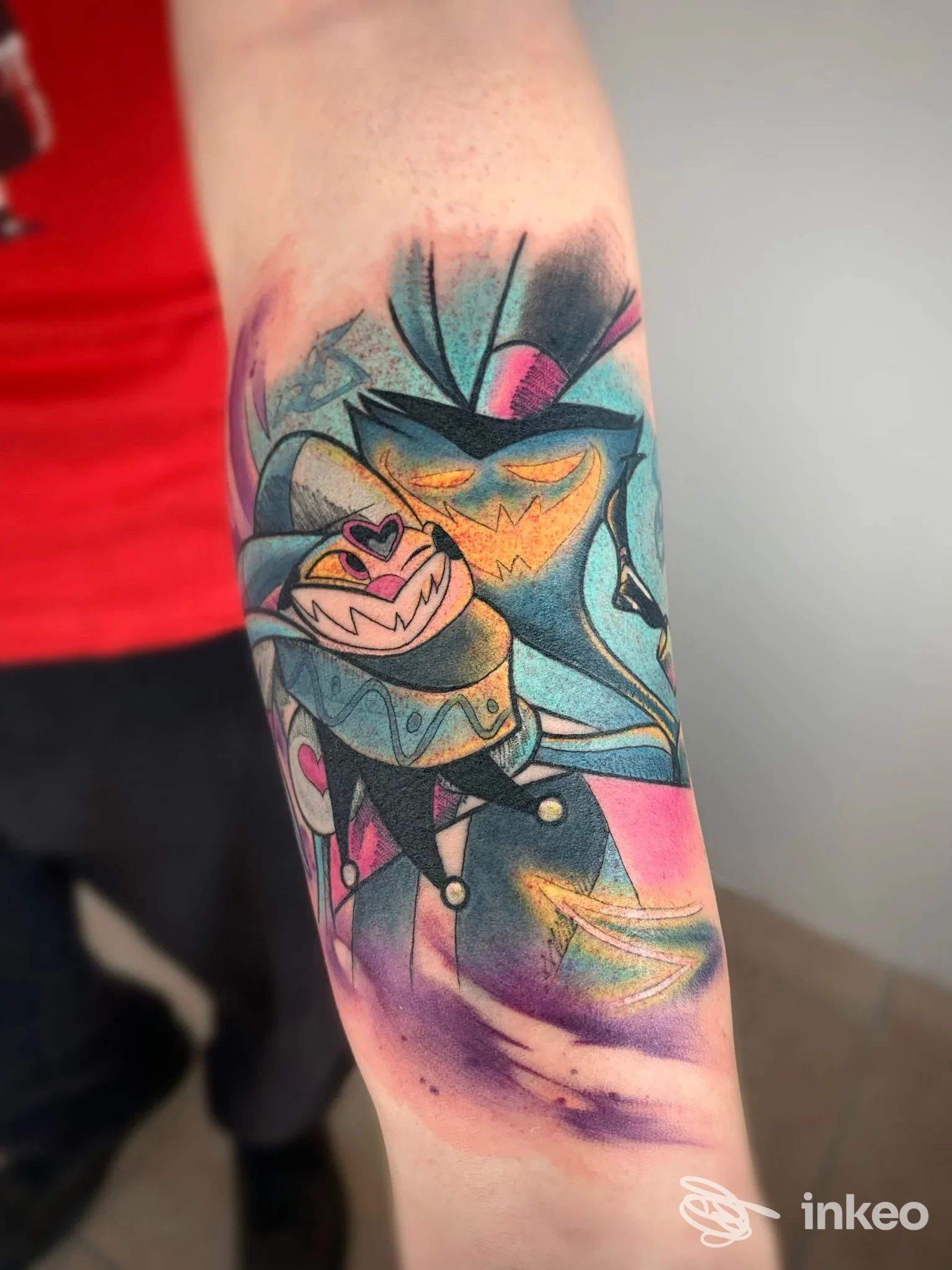 Tatuaggio colorato sull'avambraccio con personaggi stilizzati e sfumature turchesi, rosa e gialle, realizzato da Antivist Tattoo a Cascina.