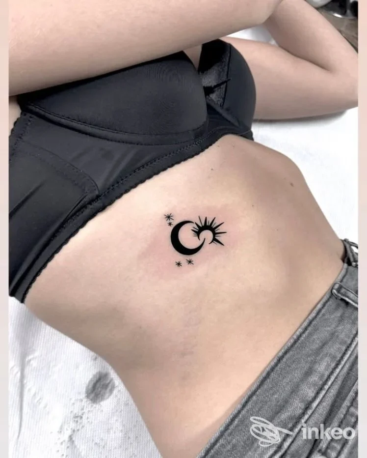 Tatuaggio minimal di luna e sole sul fianco sinistro, foto fornita da Antonini tattoo studio, Siena.