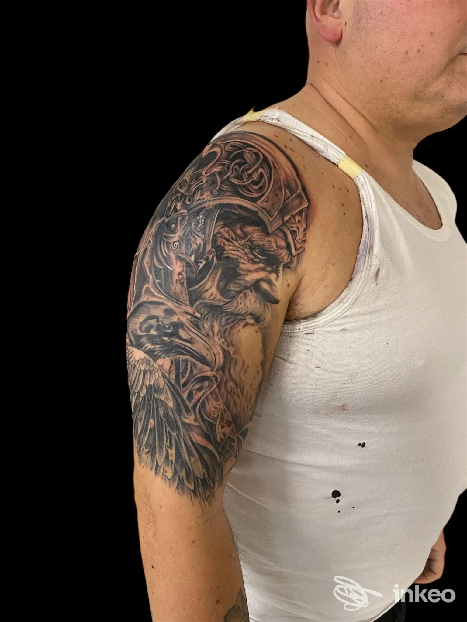 Tatuaggio realistico in nero e grigio sul braccio e spalla di un uomo, foto fornita da Arkadia Tattoo Studio, Firenze; volto visibile solo parzialmente.