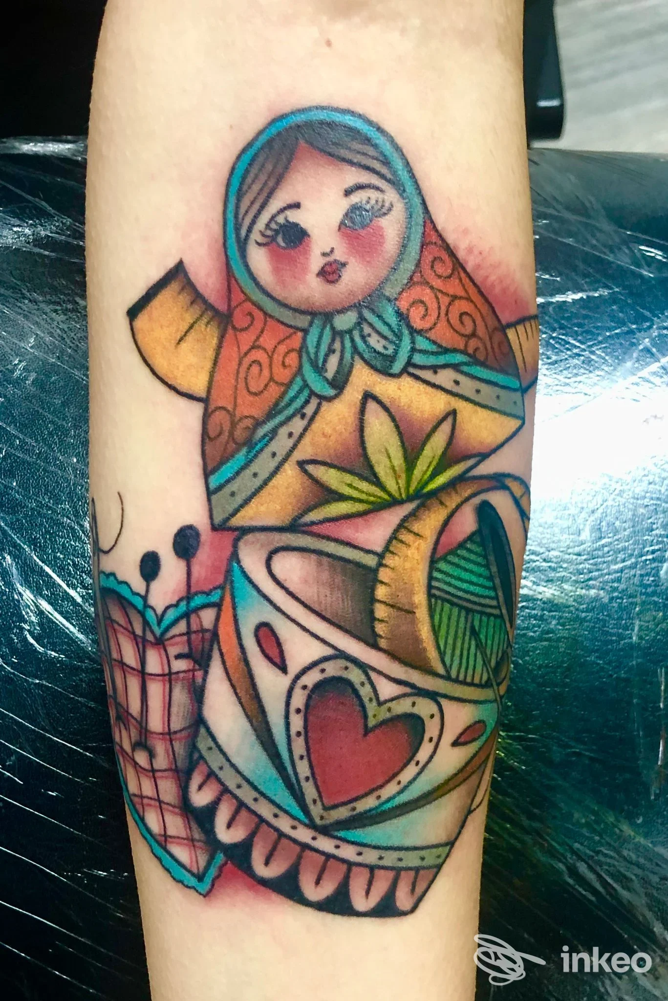 Tatuaggio colorato su avambraccio raffigurante una matrioska sopra una tazza decorata, foto inviata da Banano's Family Tattoo, Montevarchi.