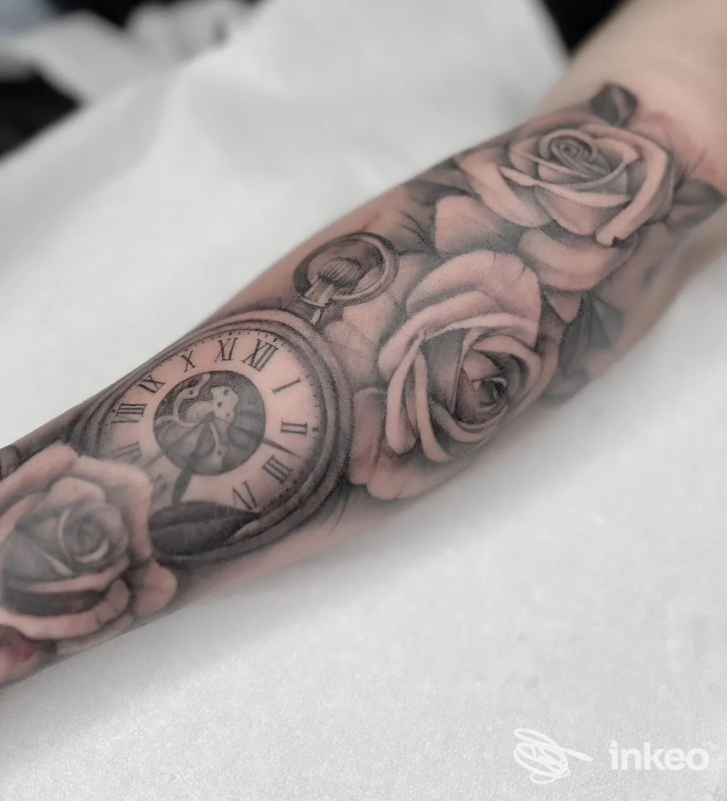 Tatuaggio realistico in bianco e nero con orologio da tasca e rose sull'avambraccio. Black Rose Tatto Studio di Michela Giorgio, Collesalvetti.