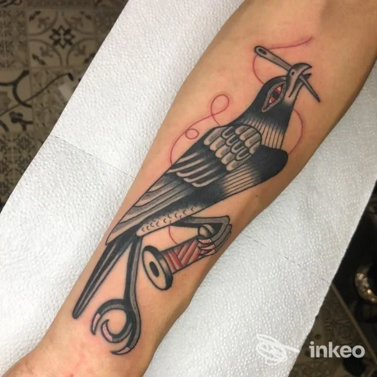 Tatuaggio sul avambraccio con corvo e forbici, foto inviata da Bohemien Tattoo Parlour, Firenze.