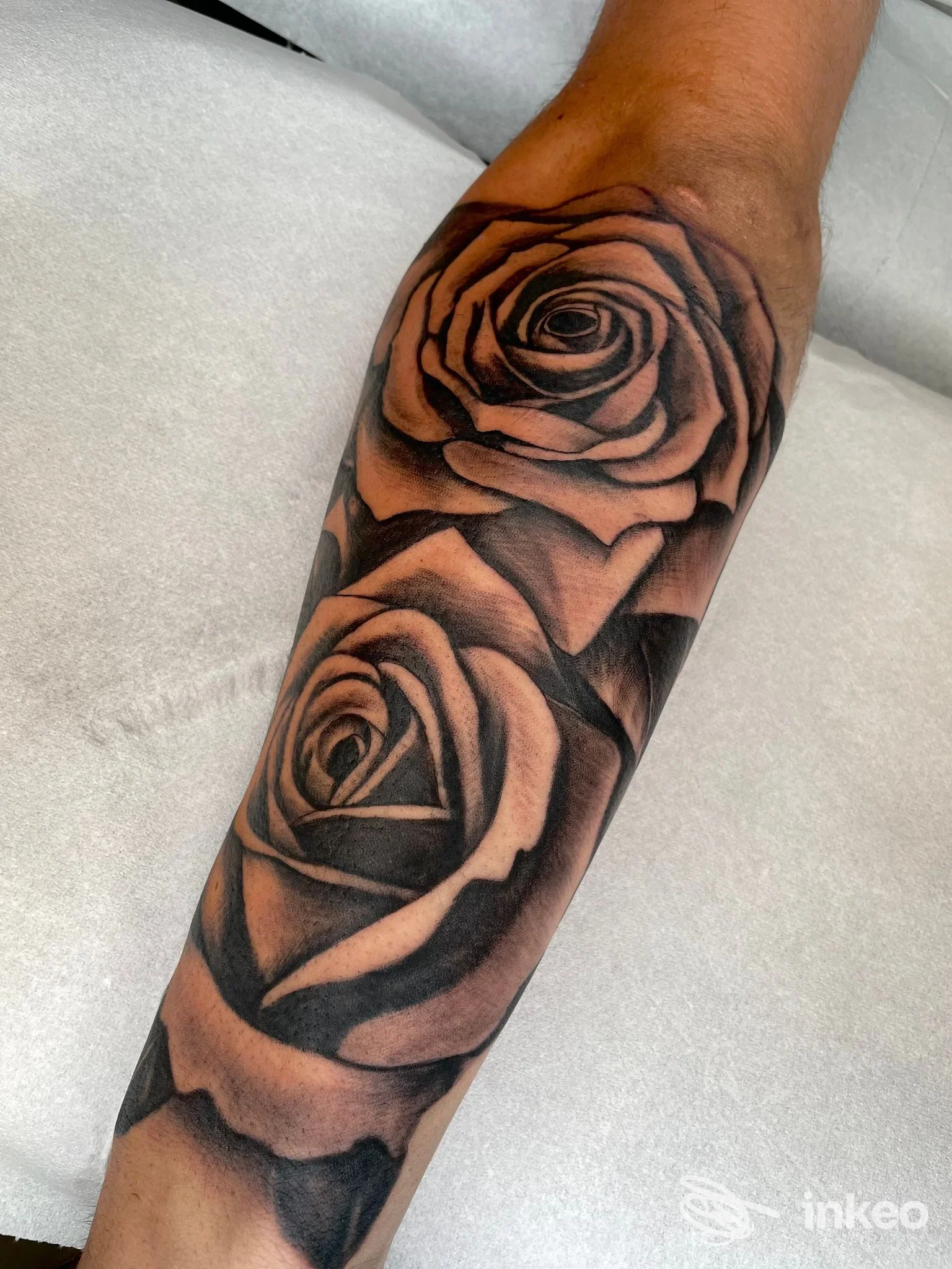 Primo piano di due rose tatuate in bianco e nero sull'avambraccio. Scattata presso Borgo 325 Tattoo studio a Livorno.
