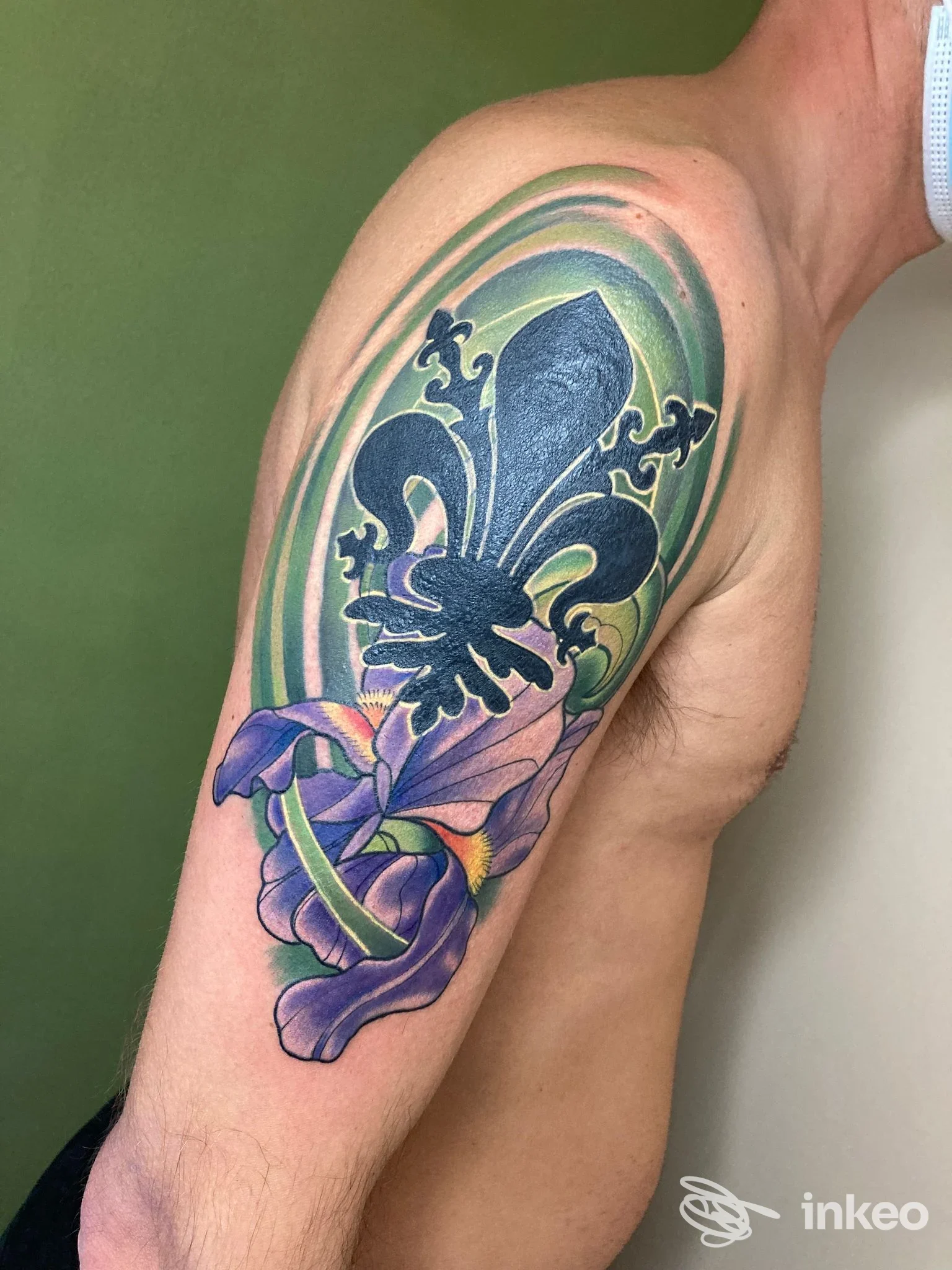 Tatuaggio a colori su spalla e alto braccio con fleur-de-lis e fiori, immagine fornita da Cotton Candy Tattoo, Tavarnuzze.