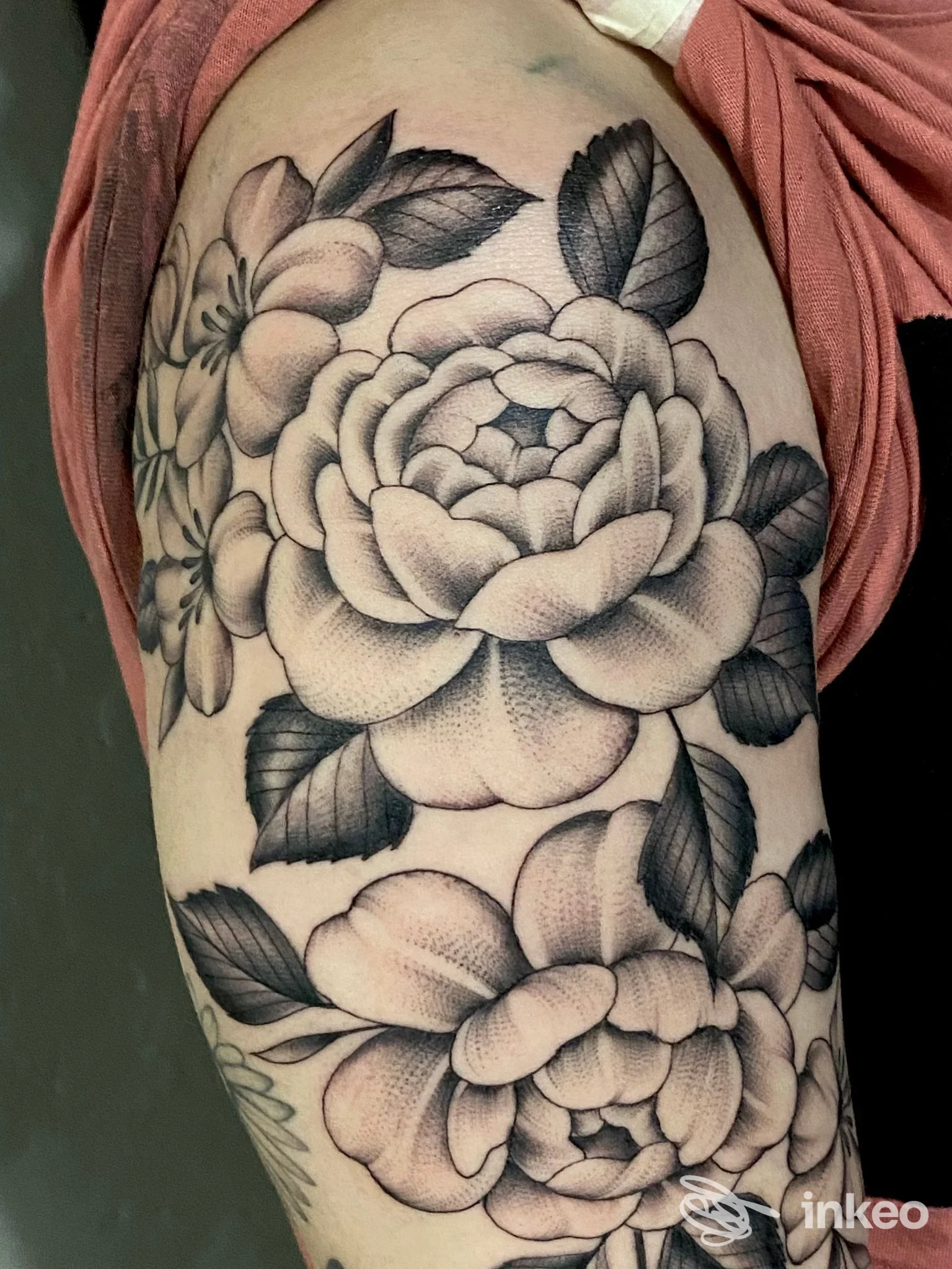 Grande tatuaggio floreale in nero sul braccio superiore, realizzato da ECLIPSE TATTOO a Certaldo.