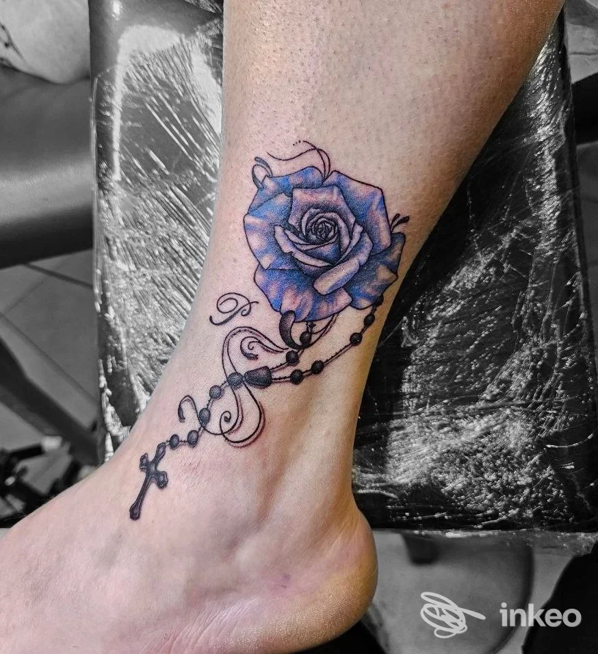 Tatuaggio a caviglia con una rosa blu e un rosario; Dark Romantics Tattoo, Lucca.