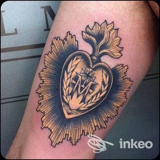 Dettagliato tatuaggio a forma di cuore sacro con fiamma e raggi in stile tradizionale sulla parte superiore del braccio, El Rana Tattoo Shop, Arezzo.