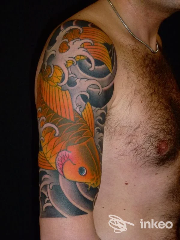 Grande tatuaggio a mezza manica con carpa arancione su braccio e spalla, foto fornita da Electric Tattooing Viareggio, Viareggio.
