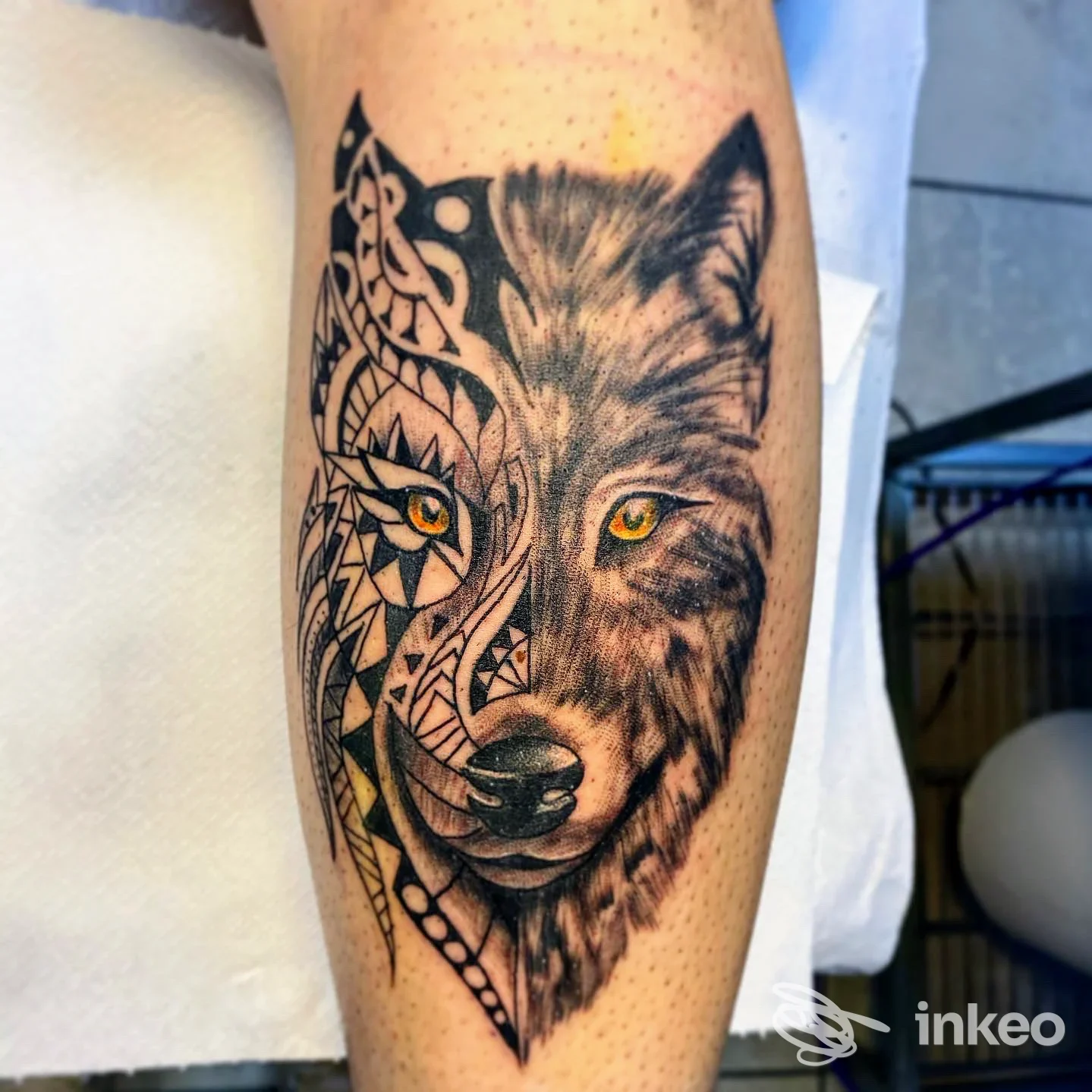 Tattoo sul braccio raffigurante un lupo metà realistico metà geometrico, con occhi gialli e dettagli intricati, eseguito da Time To Tattoo in stile noir su pelle chiara.